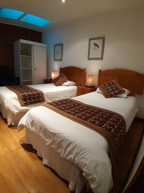 A hotel room with two beds, wooden headboards, and bedside lamps. - Hostal de La Patagonia (Punta Arenas)