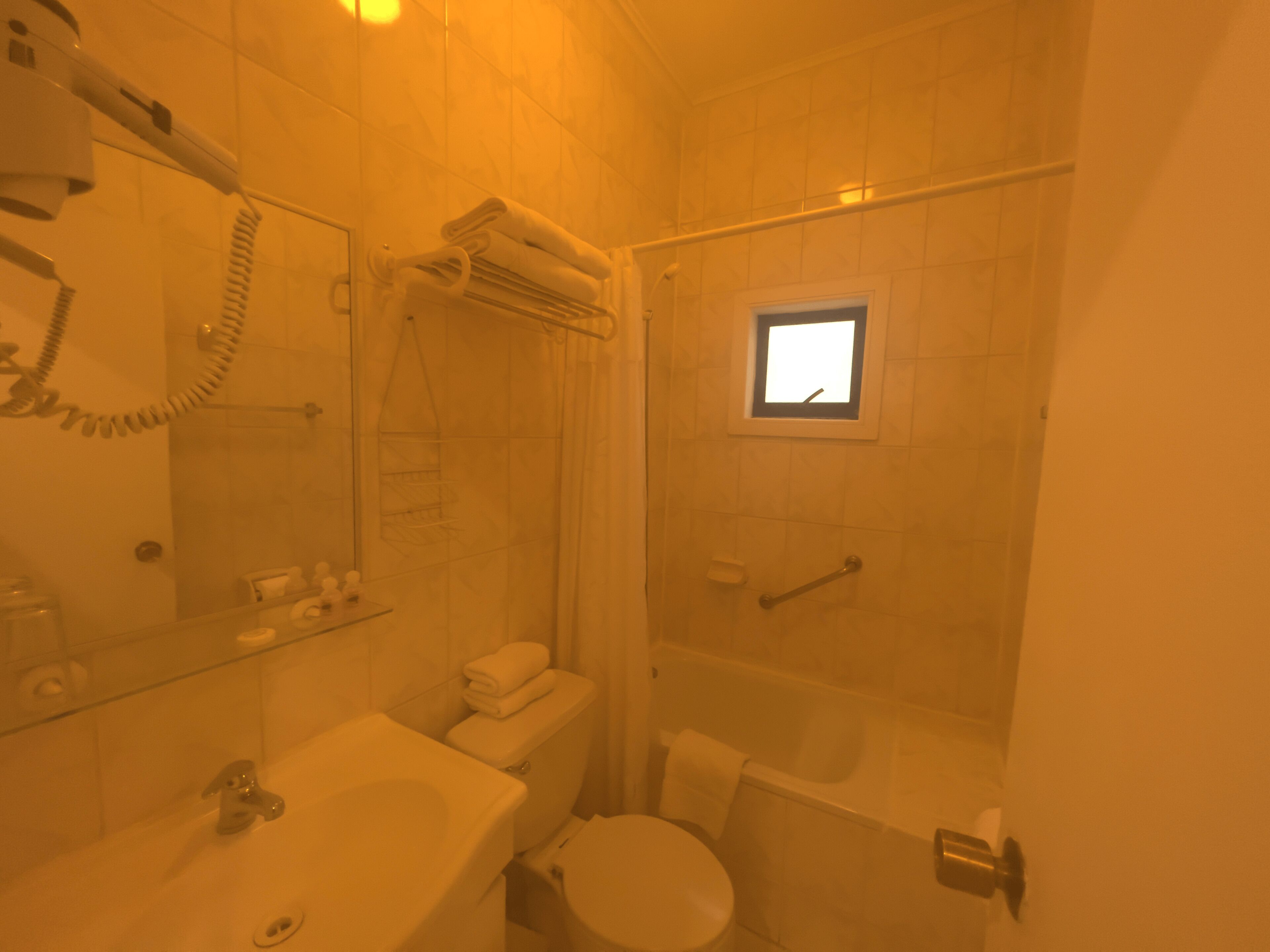 A bathroom with a sink, toilet, and shower area.