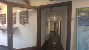 Een gang met houten balken, een donkere vloer en een kaart aan de muur.