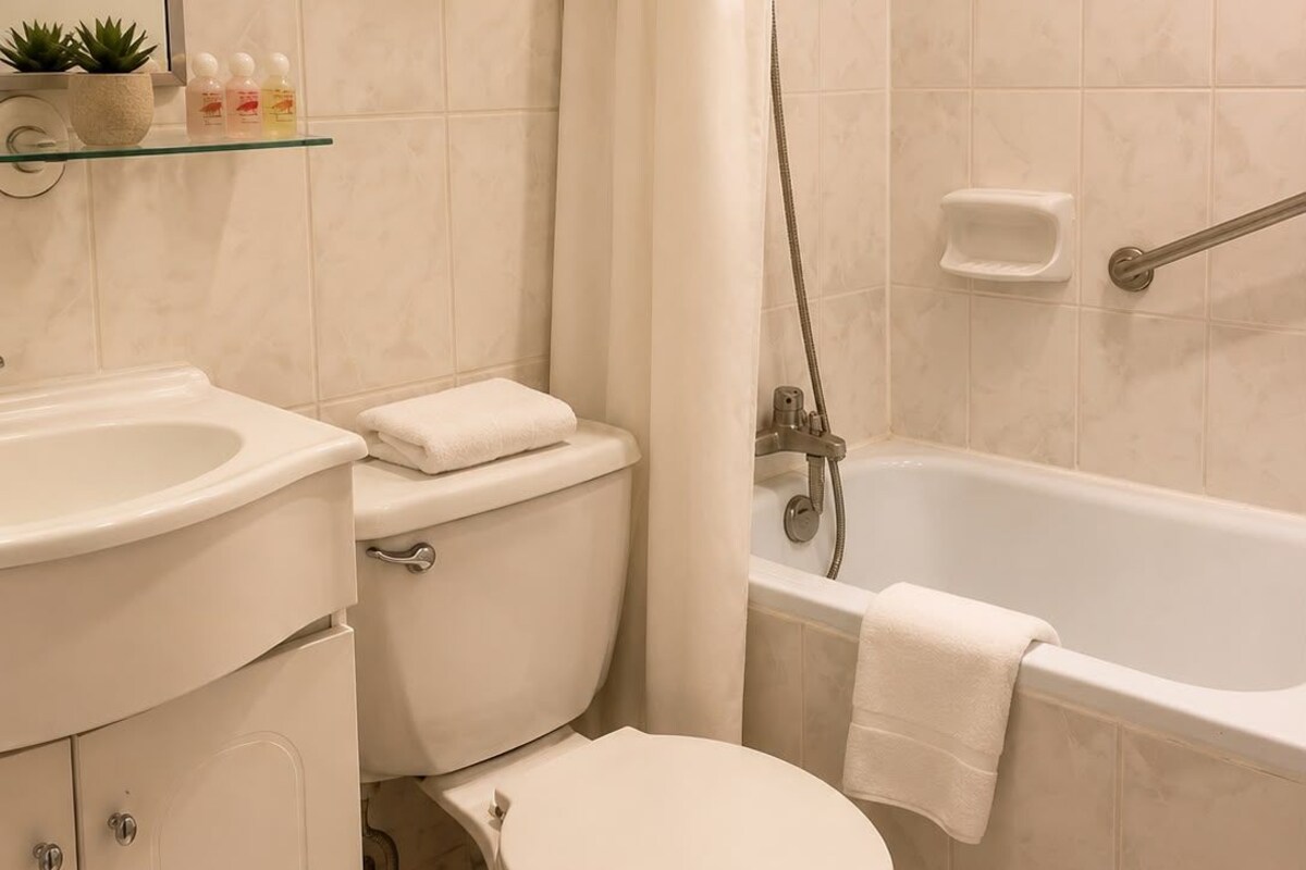 A bathroom with a toilet, sink, and bathtub.