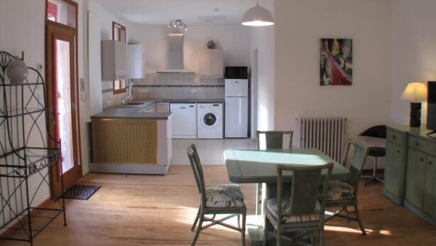 Una cocina compacta con comedor, lavadora y radiador.