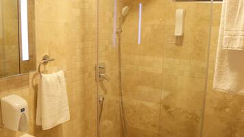 A modern bathroom with a glass-enclosed shower, a sink, and a toilet.