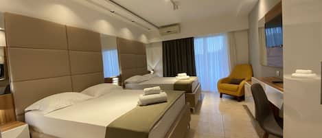 Ein modernes Hotelzimmer mit einem großen Bett, einem Schreibtisch, einem Stuhl und einem Fernseher.