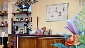 Un coin cuisine avec un comptoir en bois, une décoration sur le thème des bateaux et un tableau encadré au mur.