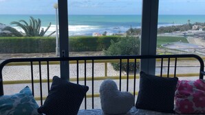 A balcony with a view of the ocean, a paved area with a skateboard ramp, and a railing with cushions. - Spectacular ocean views - 5 min walk to beach (Ericeira)