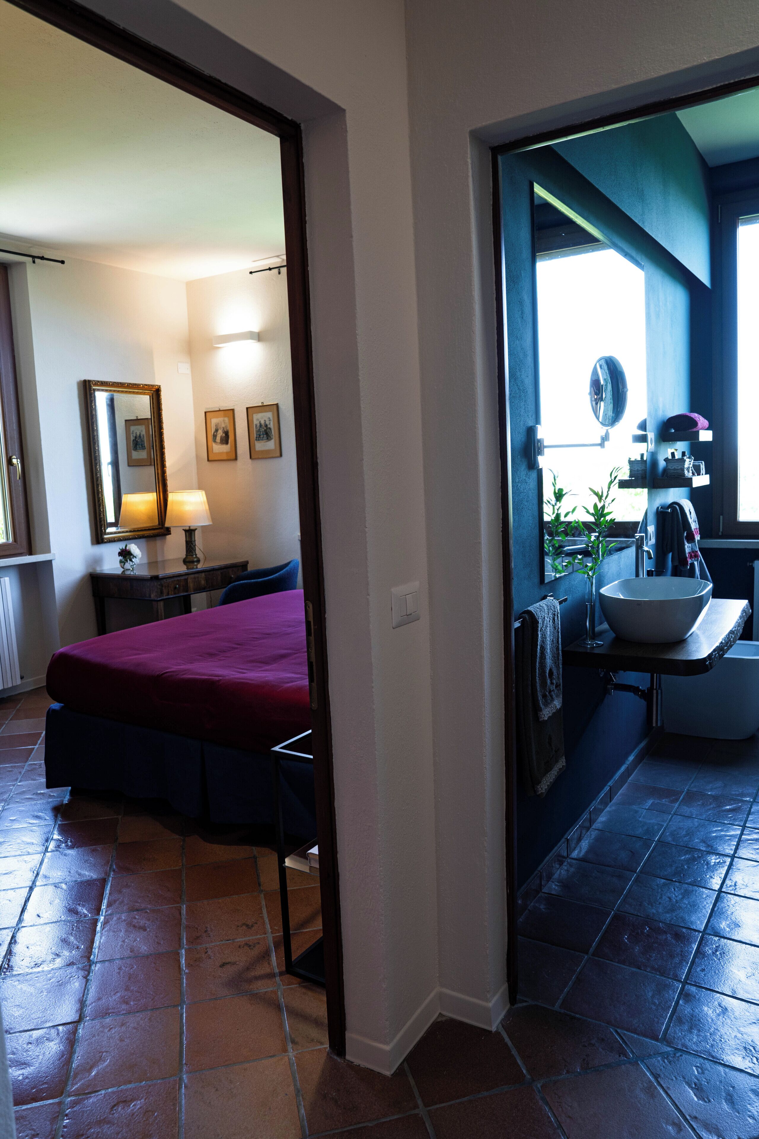 Ein Schlafzimmer mit einem Bett, einem Nachttisch mit Lampe und einem Schreibtisch mit Stuhl.
