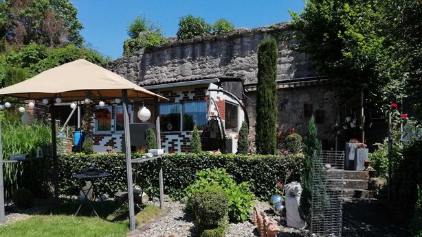 A garden with a gazebo, a stone wall, and a variety of plants. - Glori * s apartment (Bad Sooden-Allendorf)