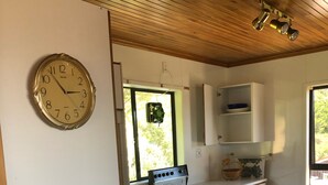 Uma cozinha com um fogão branco, um relógio e uma escultura espiral decorativa.