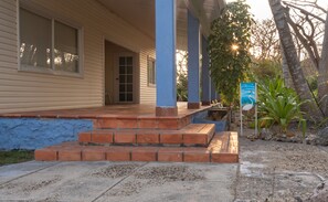 A house with a porch, a blue door, and a signboard. - Lago de los Sueños Island (Rosario Islands)