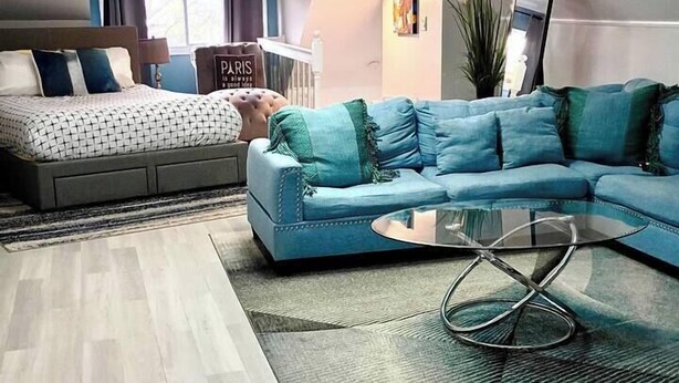 A modern living room with a sofa, a coffee table, and a bed. - Romantic Escape to The Luxury Loft (Detroit)