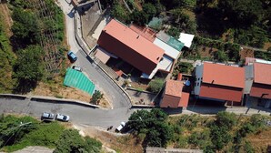 An aerial view of a residential area with buildings, a road, and greenery.