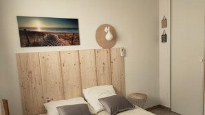 Una camera da letto con testiera in legno, due cuscini, un comodino e una sveglia a muro.