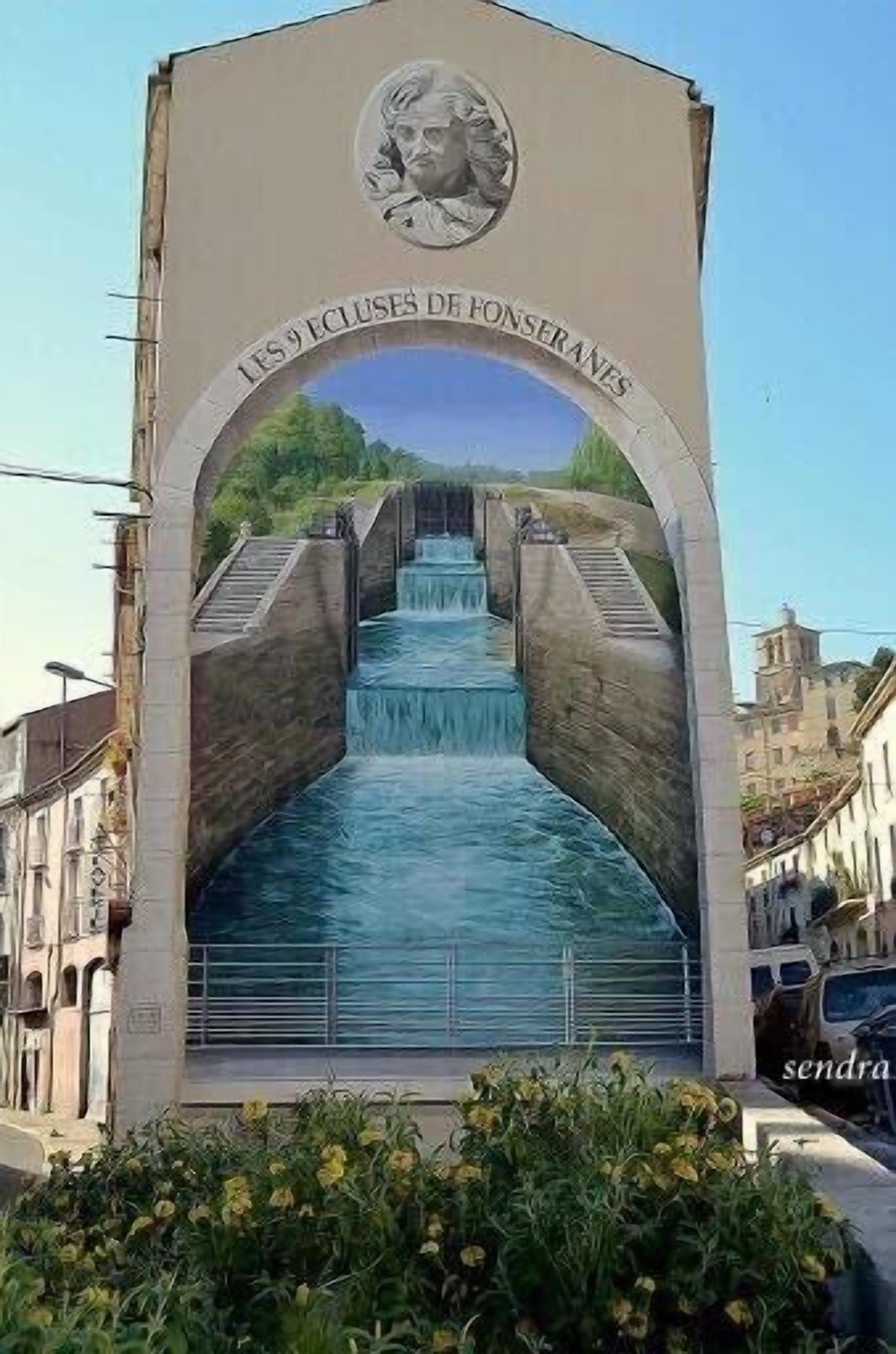 A mural of a waterfall with a staircase leading up to it, surrounded by buildings.