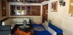 A living room with a sofa, a coffee table, and a ceiling fan. - Villa Azzurra Cuba (Havana)
