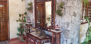 A wooden staircase with a crocodile sculpture, a mirror, and potted plants against a stone wall. - Villa Azzurra Cuba (Havana)