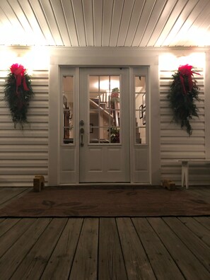 A front door with glass panels, flanked by two wreaths, leading to a staircase. - Historic Farmhouse/privacy/breathtaking views -Facebook @Valley View Escape, LLC (Collinsville)