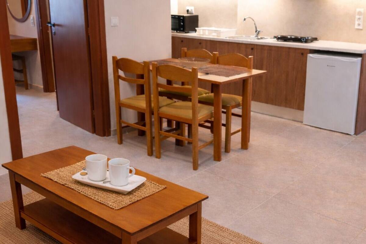 A compact kitchen with wooden cabinets, a white countertop, and a built-in dishwasher.