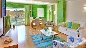 A modern living room with a white sofa, green curtains, and a dining area with a table and chairs.
