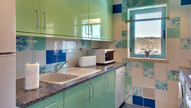A kitchen with green cabinets, a microwave, a toaster, and a sink. - Marina Sand Residence Apartment (Albufeira)