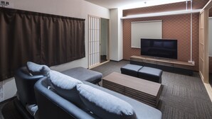 A modern living room with a sofa, a coffee table, and a television. - Randor Residence Hiroshima Suites (Hiroshima)