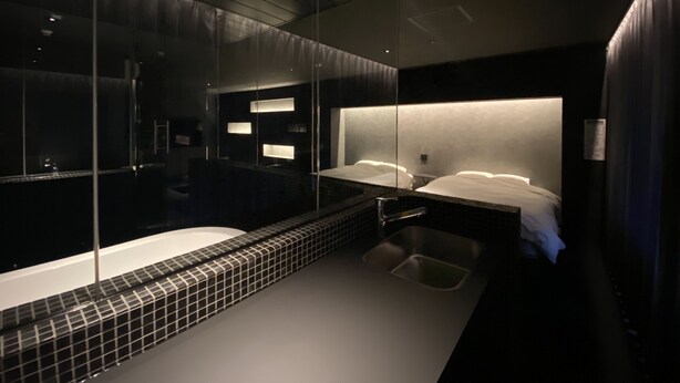 A modern bathroom with a large mirror, a bathtub, and a shower area. - Randor Residence Hiroshima Suites (Hiroshima)