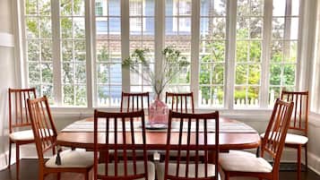 A dining area with a round wooden table and six wooden chairs.