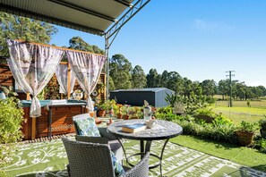 A patio with wicker furniture, a table, and a grill. - The Studio Retreat perfect for a quiet romantic break. Pet friendly, hot tub. (Quorrobolong)