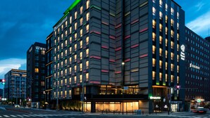 A modern hotel with a corner entrance, multiple floors, and illuminated windows. - Daiwa Roynet Hotel Kyoto Terrace Hachijo PREMIER (Kyoto)