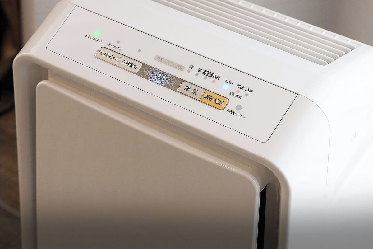 A white air purifier with a control panel featuring Japanese text and a power button.