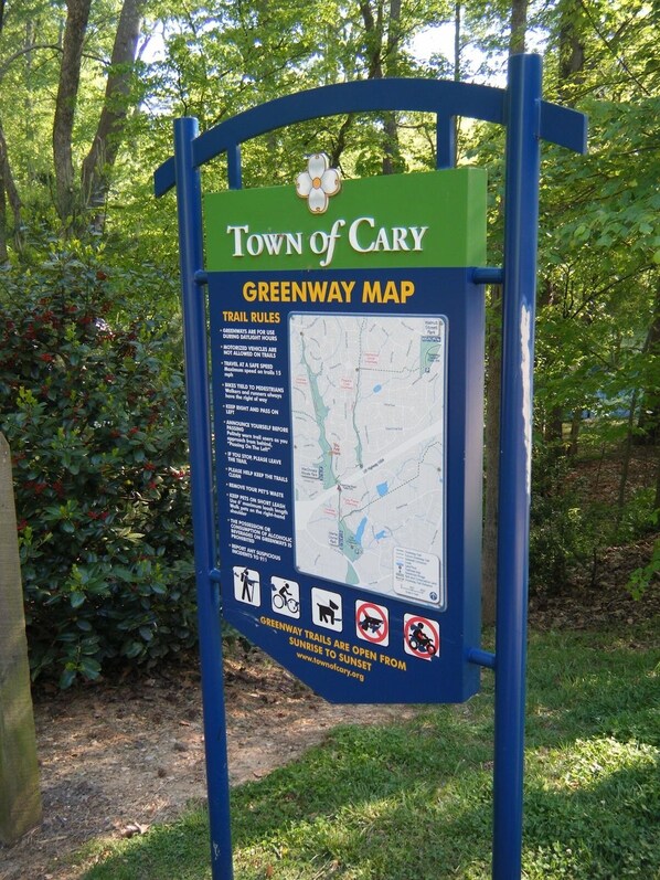 A greenway map signboard with trail rules and a map.