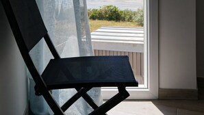 A room with a view of the sea through a window, a chair, and a curtain. - Facing the sea - 50 m from the  beach (La Guérinière)