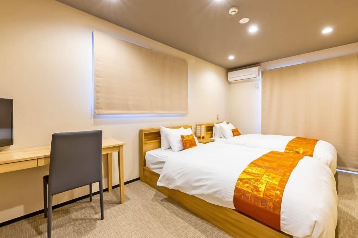 Una habitación de hotel con cama, escritorio y silla.