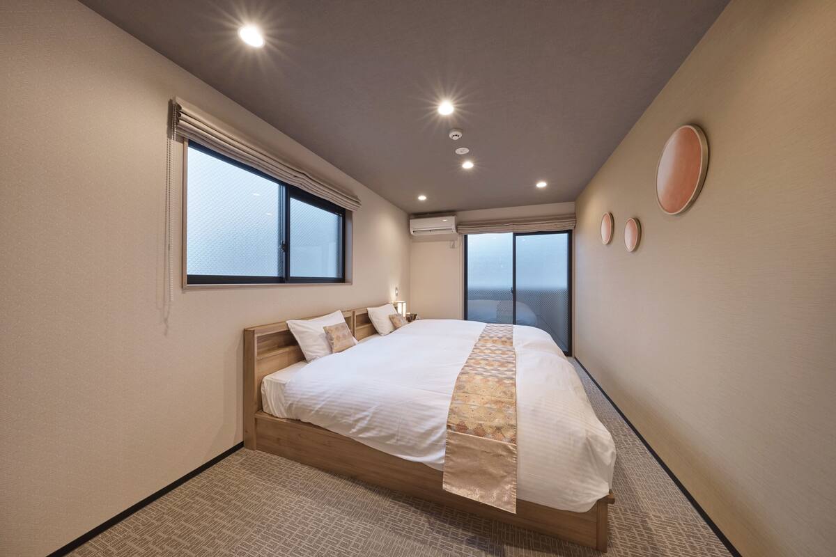 A bedroom with a large bed, a window, and a view of the sky.