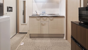 Cocina compacta con microondas, lavabo y armarios.