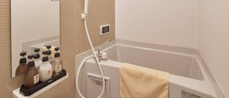 A modern bathroom with a bathtub, a toilet, a sink, and a mirror.