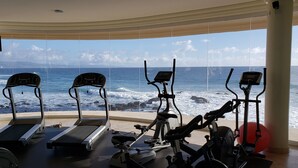 A gym with exercise equipment and a large window overlooking the ocean. - Fantastic view!!!! Romantic setting (Rosarito Beach)