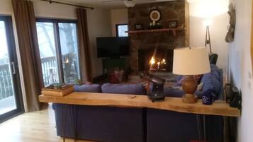 TV connectée, cheminée, livres, écrans d'ordinateur