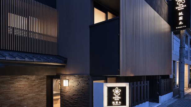Un edificio moderno con un letrero que dice 'Stay Sakura Kyoto' y un logotipo.