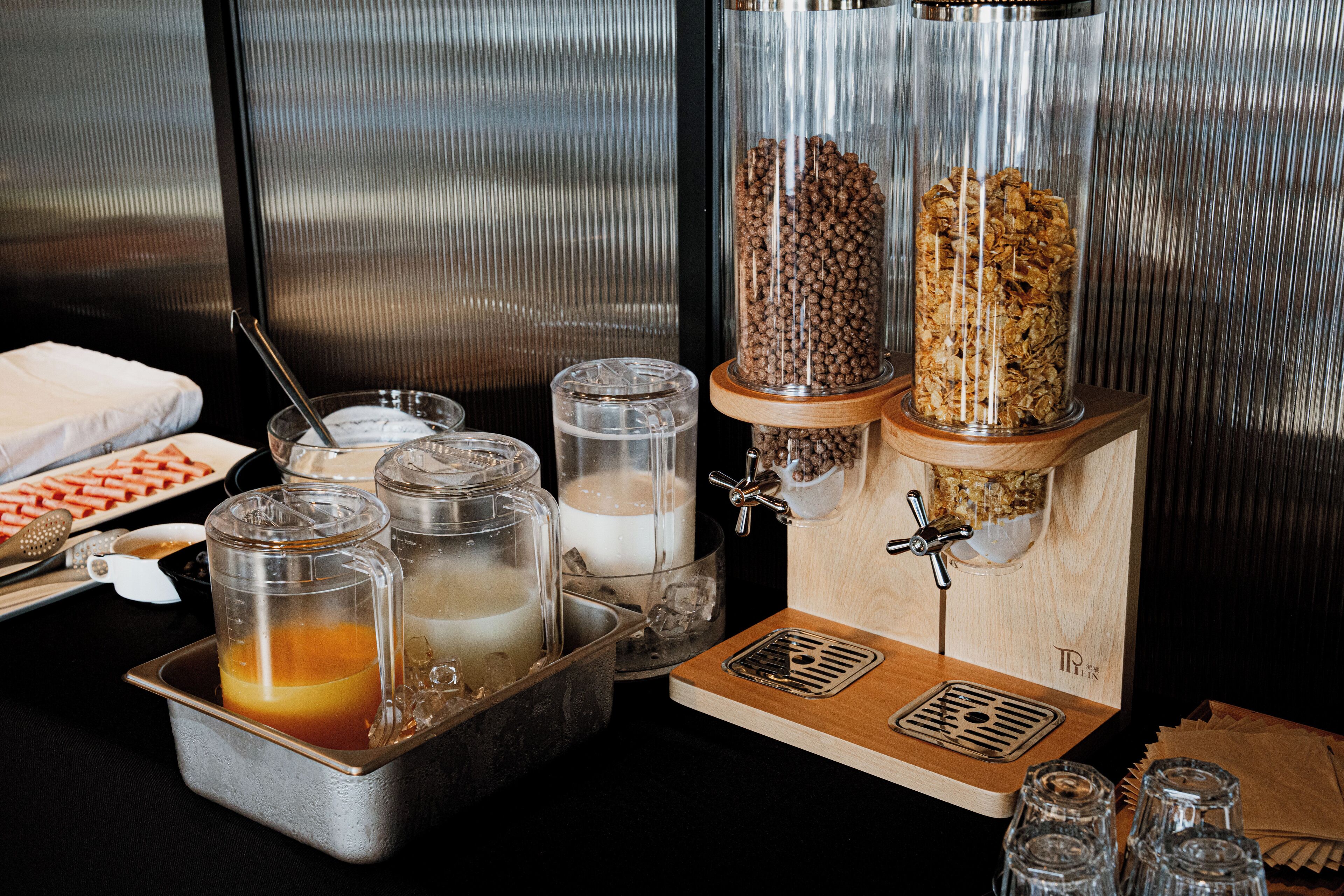 A breakfast buffet setup with various food items and beverages.