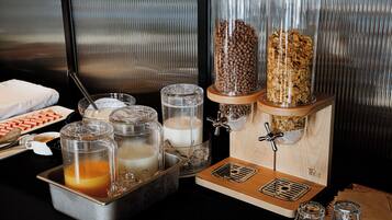 A breakfast buffet setup with various food items and beverages.
