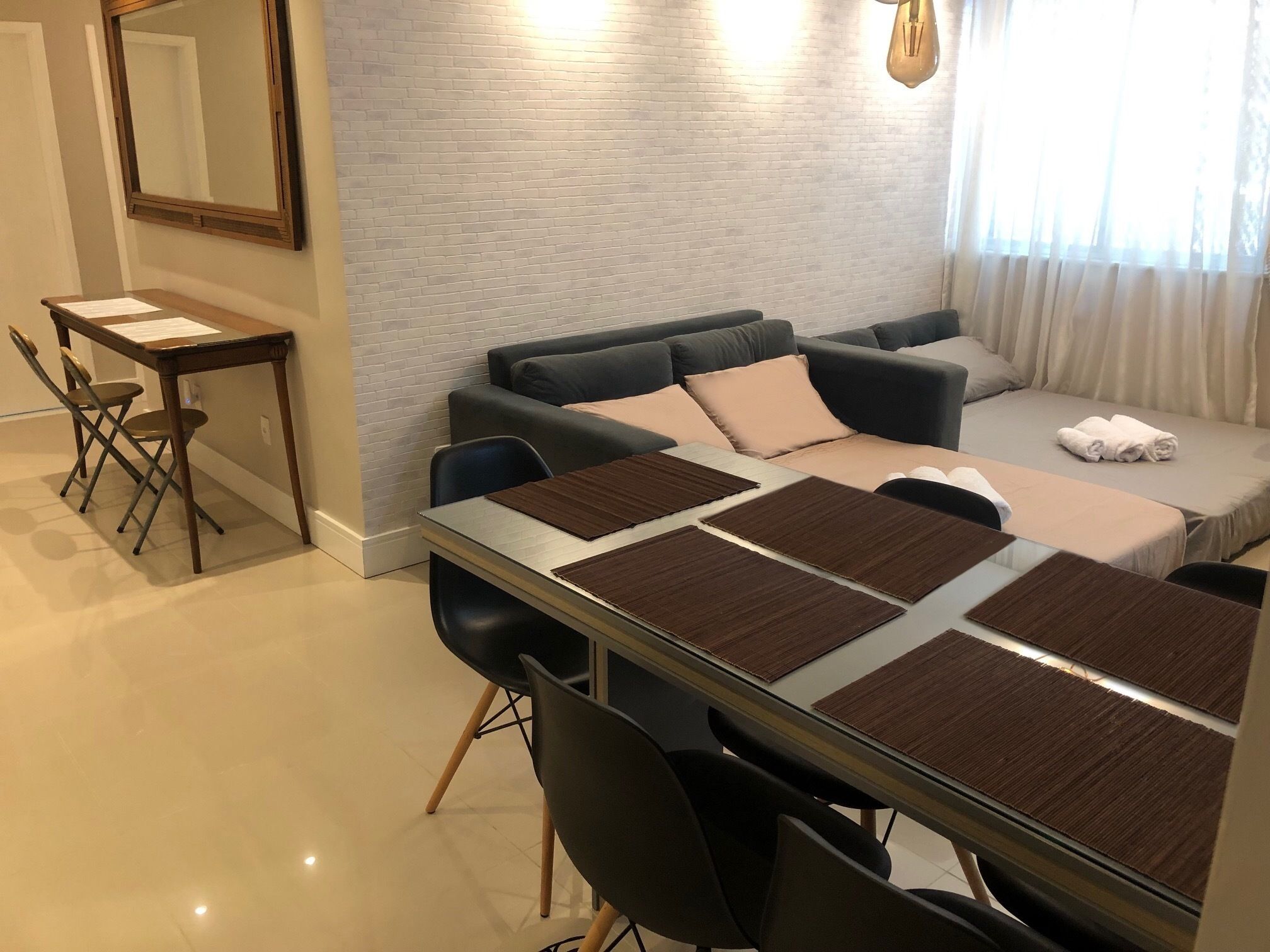 Een moderne woonkamer met een bank, een eettafel met stoelen en een klein bureau met een stoel.