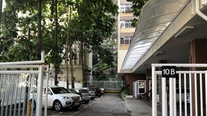 A gated parking area with several parked cars, a building entrance marked '10B', and a staircase leading to an upper level. - Welcome Rio - Ipanema Beach - Posto 9 (Rio de Janeiro)