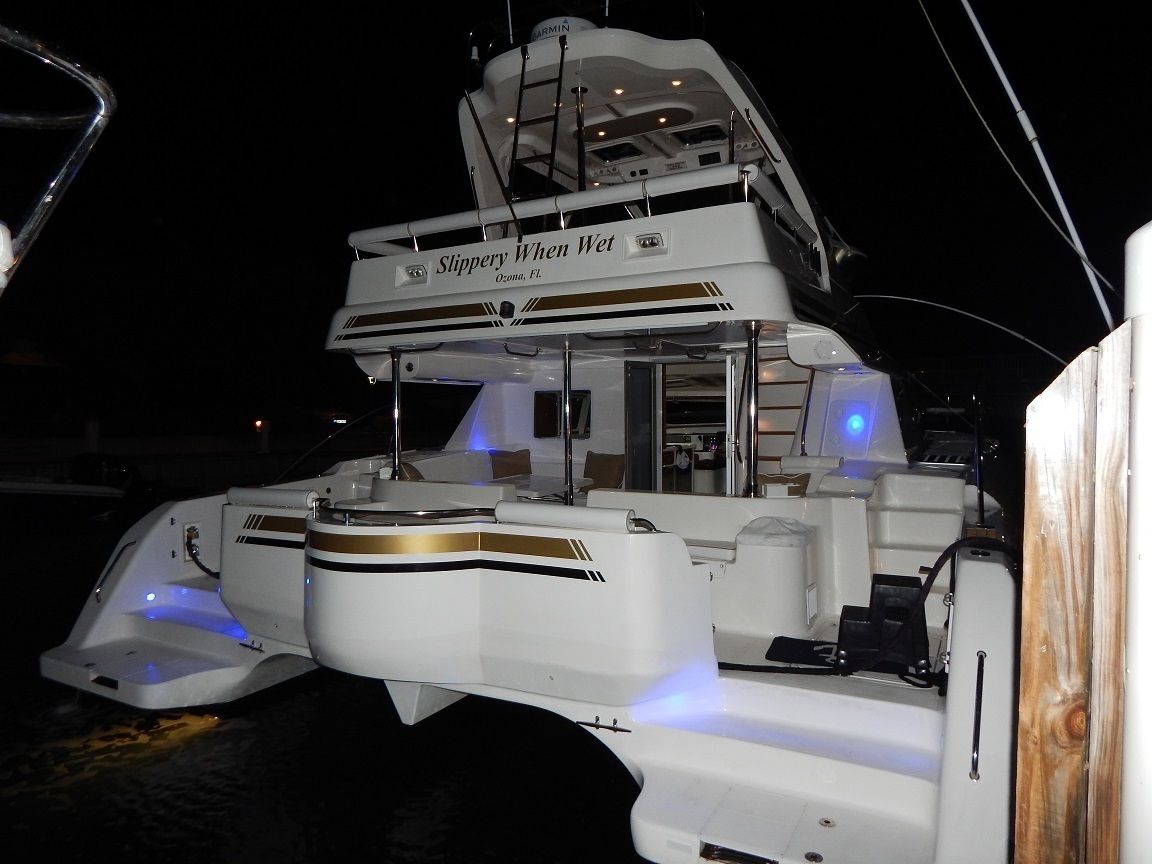 A white yacht with a nameplate reading "Slippery When Wet" and a location marker "Ozman, FL".