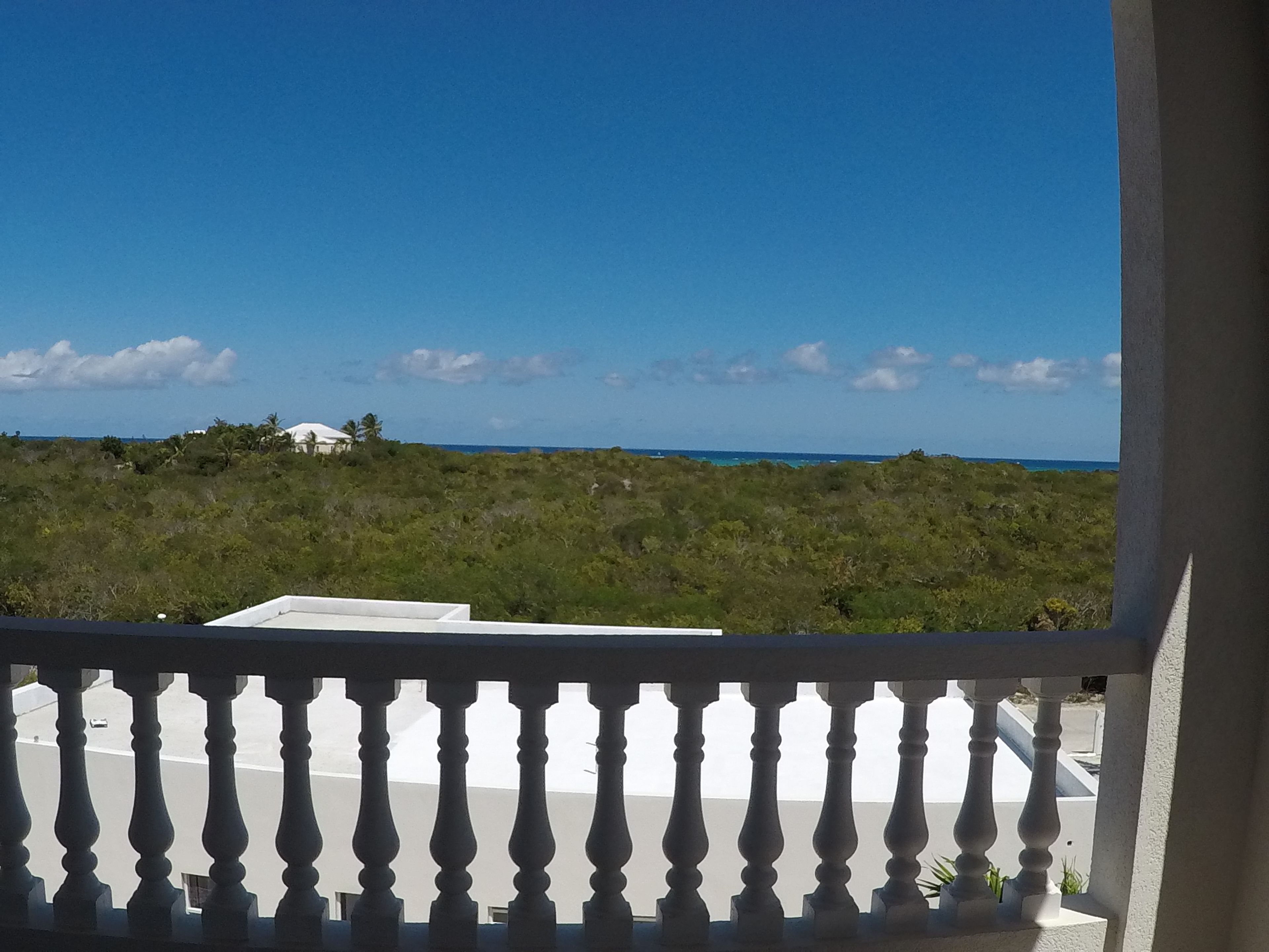 En balkon med udsigt til strand og hav.