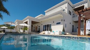 Un hotel moderno con piscina, zona de estar al aire libre y un patio cubierto.