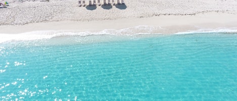 A strandtól nem messze, fehér homok, napozóágyak és napernyők