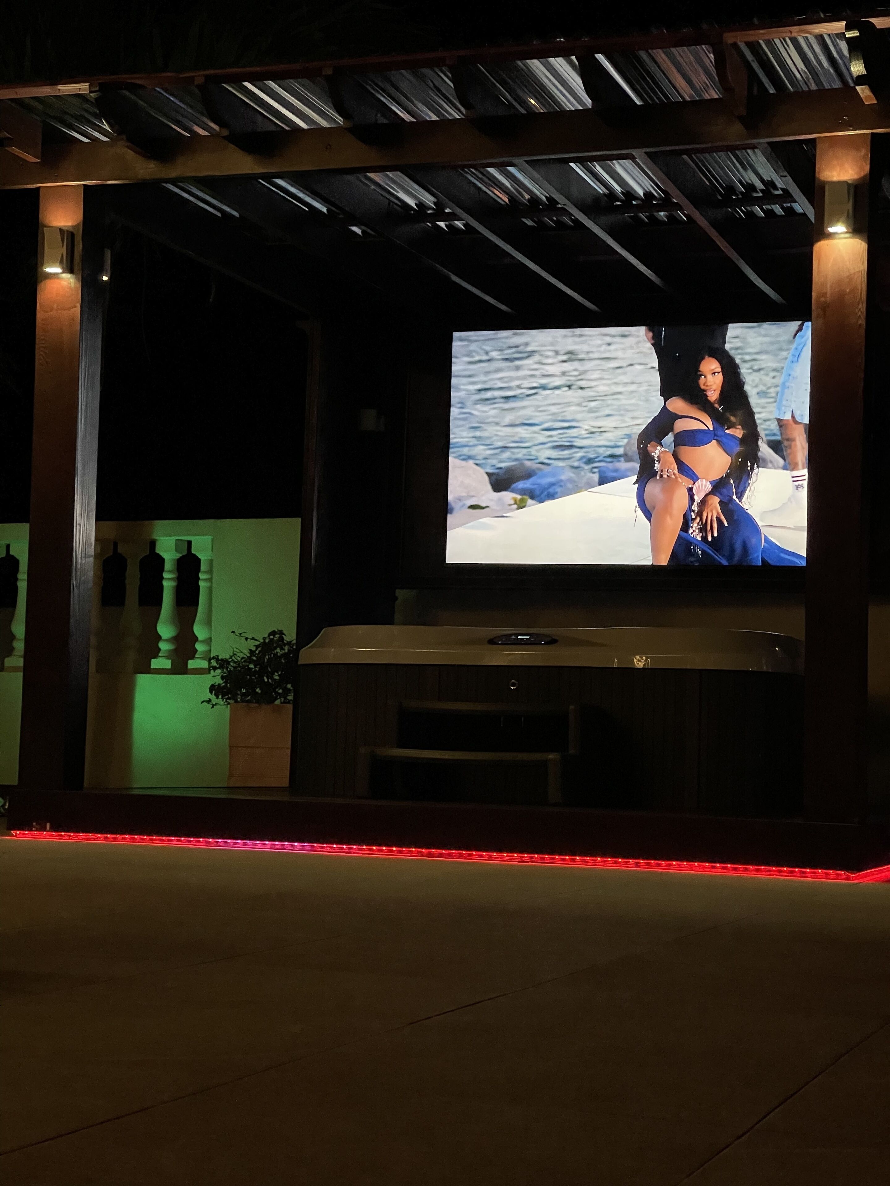 A darkened room with a large screen displaying a person on a boat.