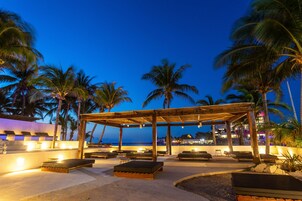 Una piscina al aire libre, sombrillas, sillones reclinables de piscina