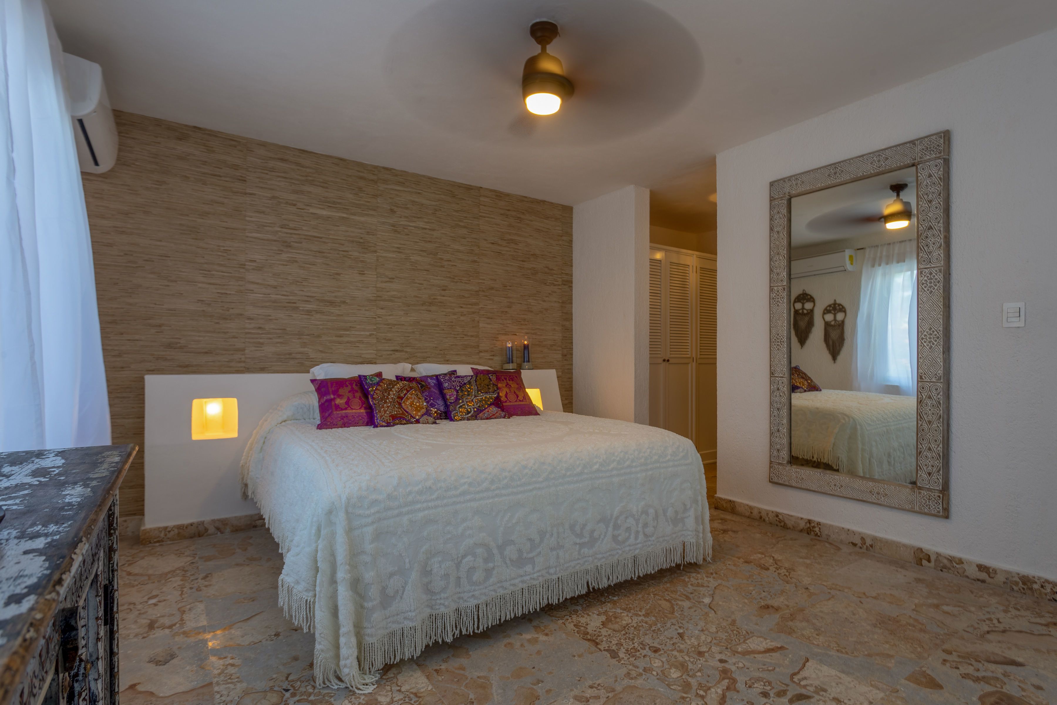 Une chambre à coucher avec un lit, un miroir et un mur en bois.