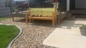 A house with a front porch, a wooden bench, and a gravel driveway. - Perfect get away that is minutes from Legendary Downtown Sturgis! (Sturgis)